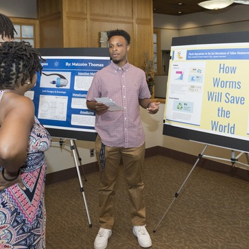 COE-RISE_Academy_Closing_Ceremony-ME-081222 A student presents his research poster at the RISE Academy graduation.