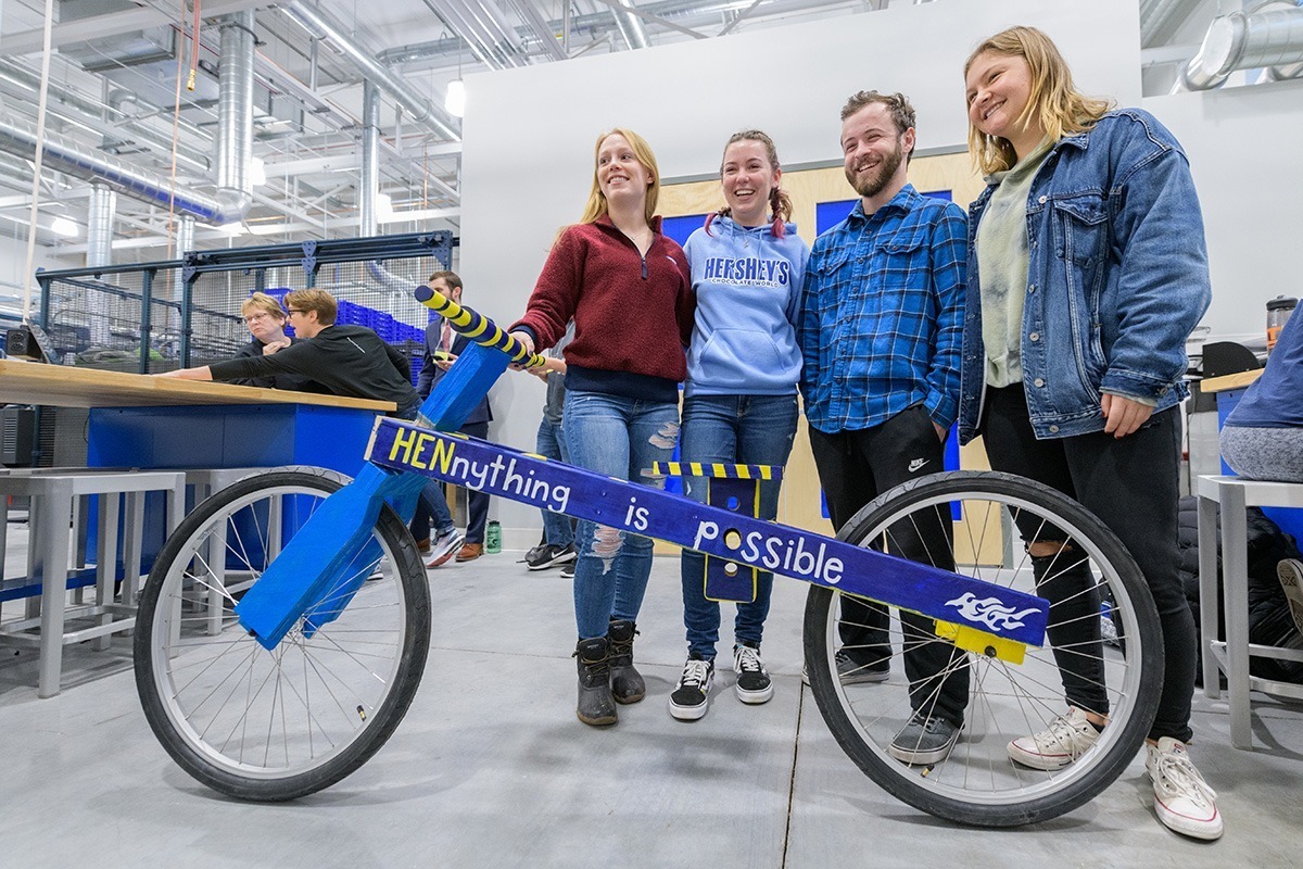 mechanical-engineering-major-finder Mechanical engineering students stand with the wooden frame bicycle they built in a hands-on design class.