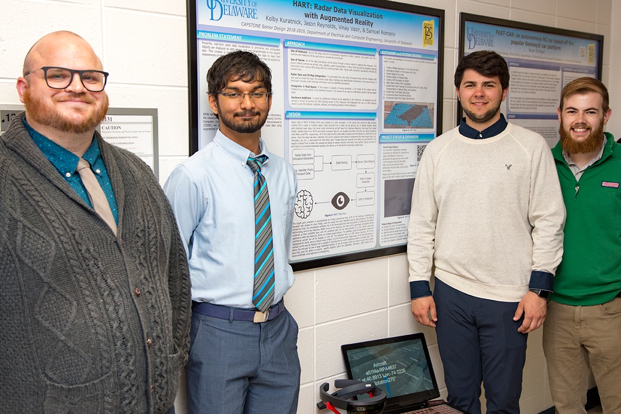 A group of students is pictured with a research poster. 