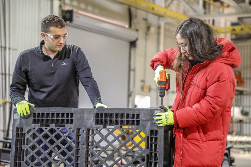 Lucas Attia (left) and Phoebe Dowden drill together pallets for the Early Learning Center's outdoor learning environment re-design.
