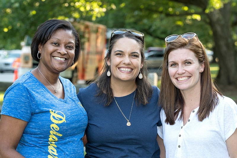 Three smiling female staff members in casual clothes