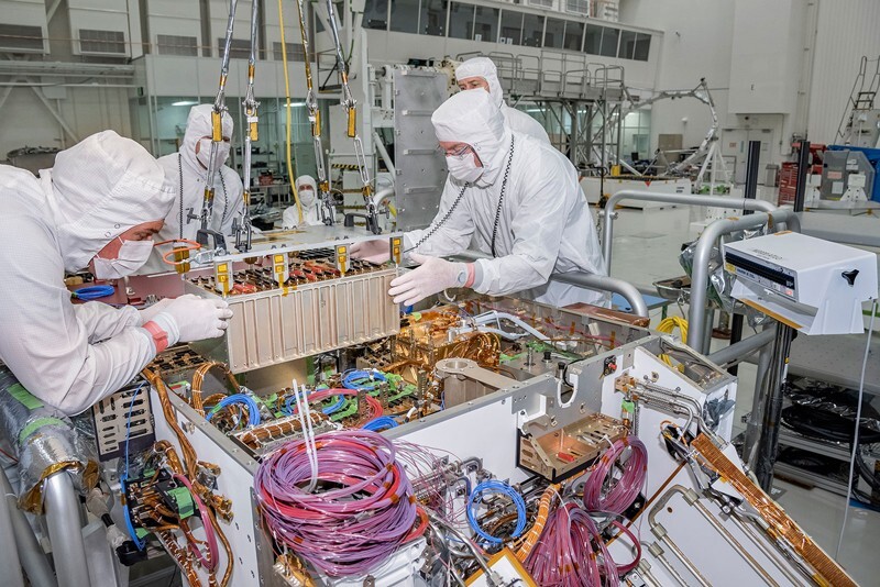 Technicians working on the Mars 2020 rover at NASA’s Jet Propulsion Laboratory install the rover motor controller assembly, the electrical heart of the rover's mobility and motion systems.