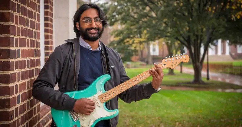 Doctoral student and 2020 George W. Laird Fellowship winner Prashant Ramesh playing a teal electric guitar