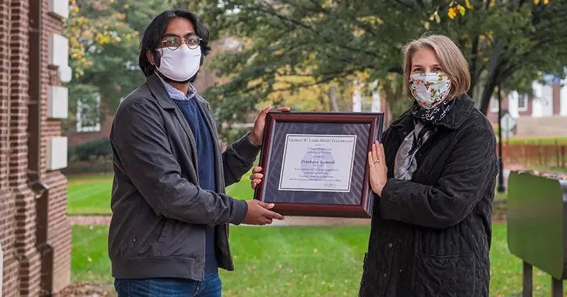 Prashant Ramesh (left) is handed the framed Laird Award by Margaret Laird.