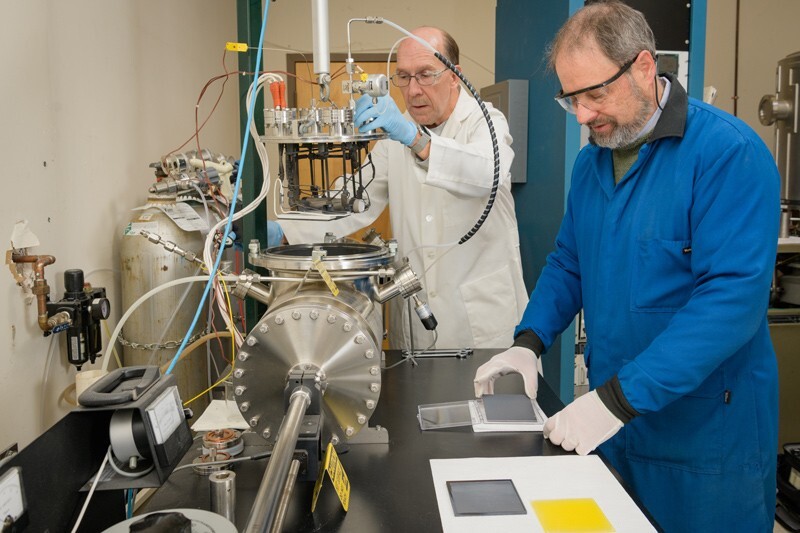 UD scientist Brian McCandless (right) worked as an associate scientist with the Institute of Energy Conversion (IEC). In this photo, McCandless is working with Wayne A. Buchanan, who was a research associate at the IEC.