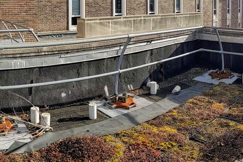 Several concrete cylinders on the roof of Spencer Lab. Some cylinders are upright and some on their sides. 