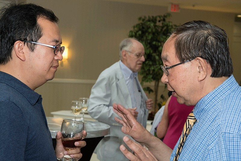 At a 2016 reception, Dr. Gao chats with Xiaoming Li, associate professor in the department. Stanley Sandler, H.B. du Pont Professor Emeritus, can be seen in the background.