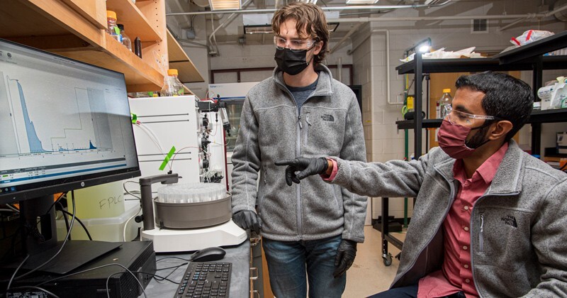 Aditya Kunjapur (right), an assistant professor in the Department of Chemical and Biomolecular Engineering, works in his lab with Neil Butler. Kunjapur has been awarded the 2021 American Institute of Chemical Engineers (AIChE) Langer Prize for Innovation and Entrepreneurial Excellence, a highly competitive award that comes with a stipend to pursue “blue sky” ideas.