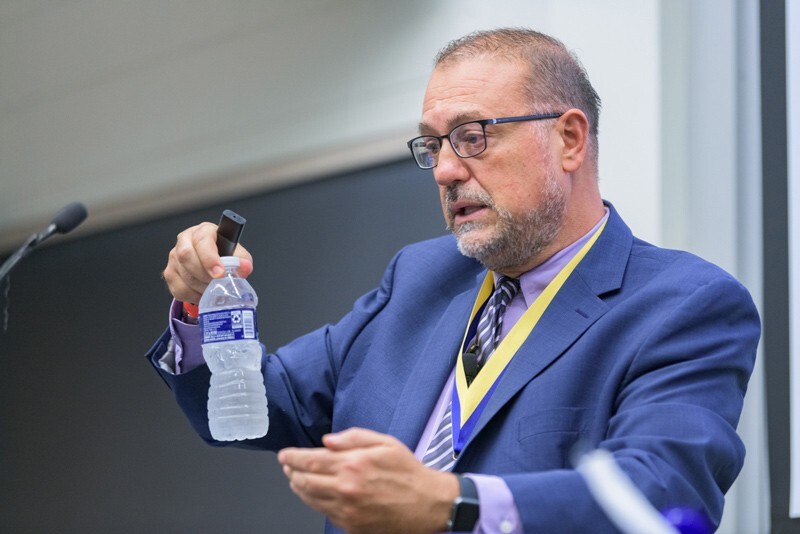 Dionisios Vlachos, Unidel Dan Rich Chair in Energy Professor of Chemical and Biomolecular Engineering, holds up a plastic water bottle during a lecture.