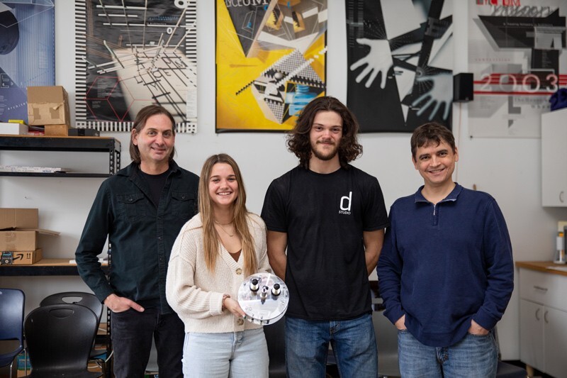 Ashley Pigford (far left), associate professor of art and design, leads a project — supported by the Maggie E. Neumann Health Sciences Research Fund — to advance his invention, the PushnDraw® assistive drawing device for children with upper limb disabilities. Pigford is working with Adam Wickenheiser (far right), associate professor of mechanical engineering, and mechanical engineering students Sara Dugan (second from left) and Logan Butler on this interdisciplinary research project.