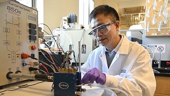 Yushan Yan working on a device in his lab.