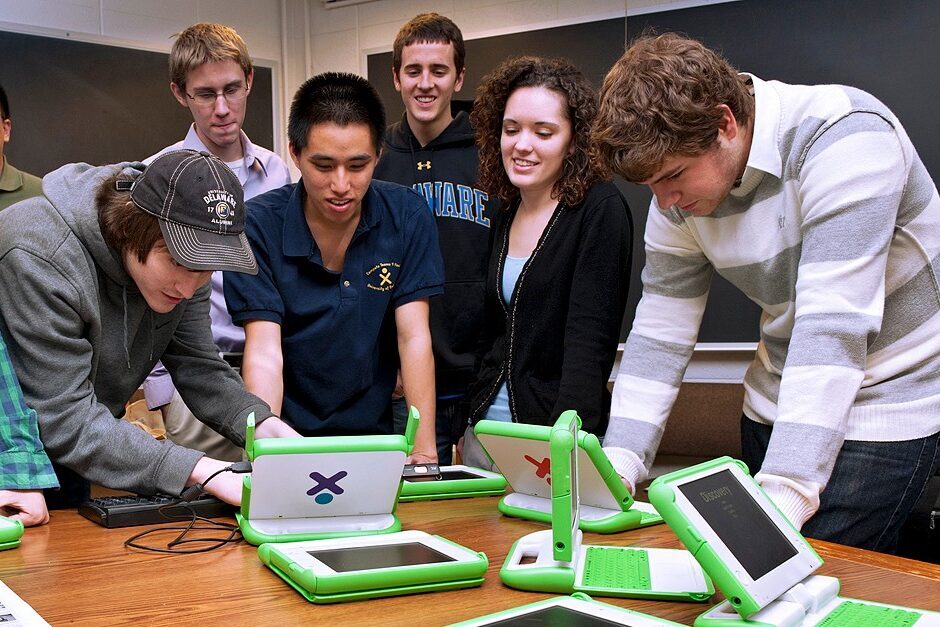 Students in a learning game development class collaborate on laptops.