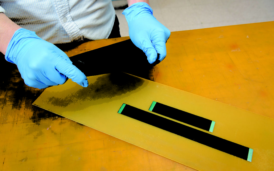gloved hands touch a nanotube-based sensor material