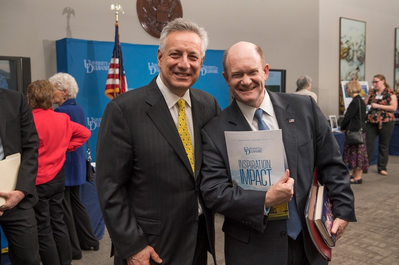 U.S. Sen. Chris Coons (right) has a degree in chemistry and is a powerful advocate for University of Delaware research. Here he shows off his new copy of UD President Dennis Assanis’ annual report. 