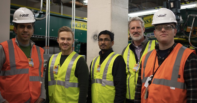 The research team is pictured at at Ted Stevens International Airport in Anchorage. The column in the background is retrofitted with a fiber-reinforced polymer composite. From left to right: Siamak Sattar, research structural engineer, Earthquake Engineering Group, National Institute of Standards and Technology (NIST); Jovan Tatar, assistant professor, Department of Civil and Environmental Engineering at the University of Delaware; Shafique Ahmed, doctoral candidate, Department of Civil and Environmental Engineering at UD; Jeff Robertson, director of engineering, QuakeWrap, Inc; David Goodwin, research chemist, Polymeric Materials Group, Engineering Laboratory, National Institute of Standards and Technology (NIST).