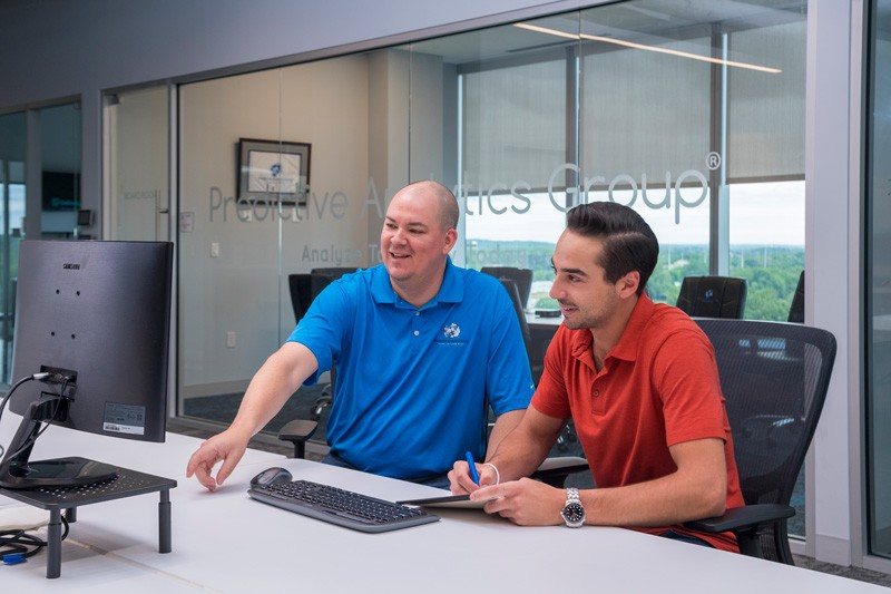 David LaRoche (left), managing partner at Predictive Analytics Group and a University of Delaware alumnus, works with Carson Furci, who graduated with his degree in entrepreneurship from UD this past May. Furci did a student internship with the company and is now employed there full-time as a marketing/business analyst.