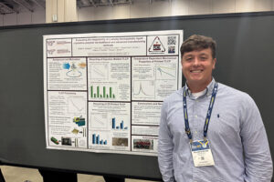 Will Quintana poses next to his scientific poster.