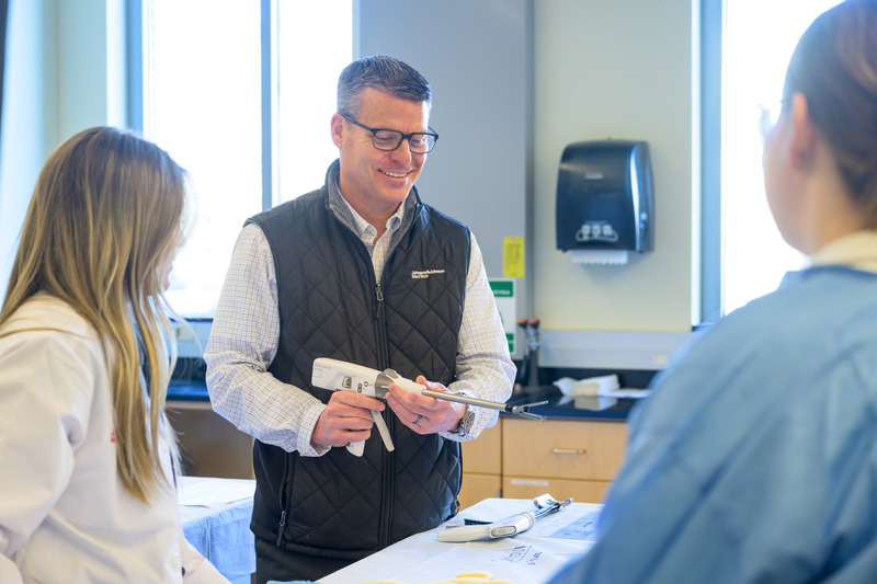 J&J MedTech’s Glenn Magrini (black vest) co-developed the lab with Rooney and helps support the STRs during their teaching experience.