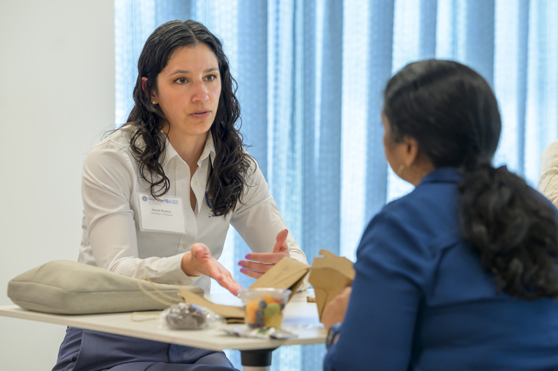 Rooney converses with another conference participant.